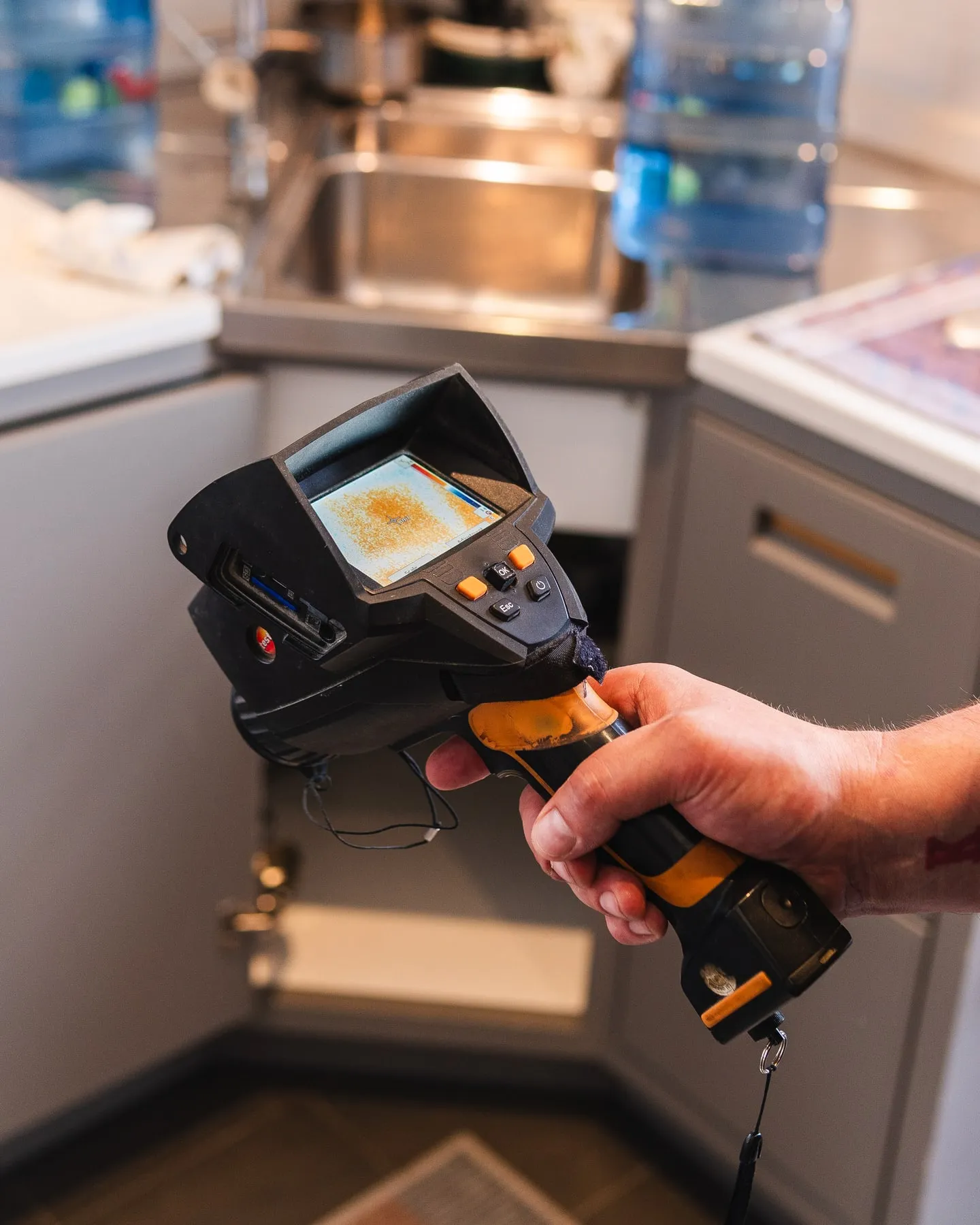 Thermal camera showing temperature differences around kitchen pipework